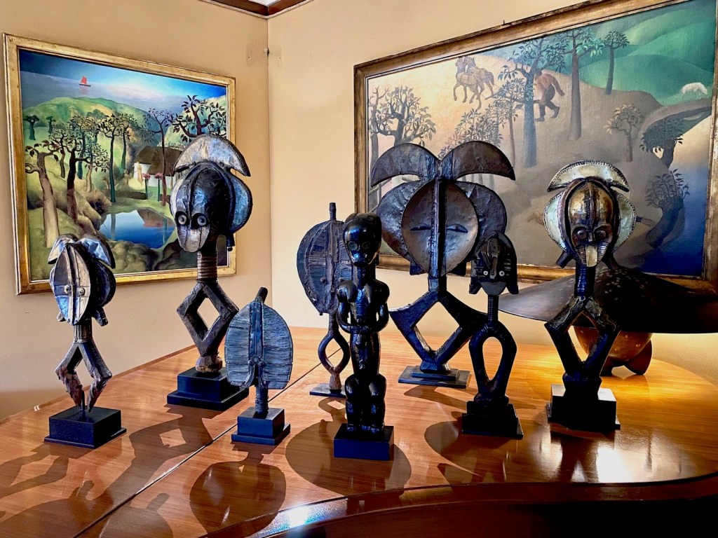 Several Kota reliquary figures presented on a piano cover during a special exhibition organized by Didier Claes at the Van Buuren Museum in Brussels.